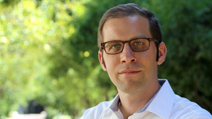 Portrait photo of Joel Tropp. He wears glasses and a white shirt.