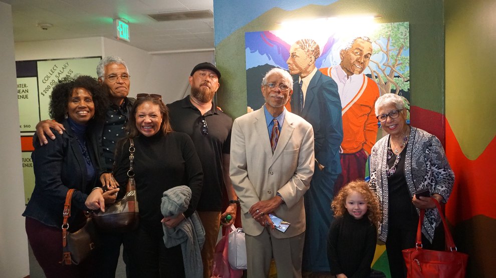 June Edmonds and the Venerable family pose with the portrait of Grant D. Venerable. From left to right: June Edmonds, Lloyd Venerable, Michelle Ellington, Billy Stinchcomb, Grant D. Venerable II, Stella Stinchcomb, and Lynda Venerable Ellington.