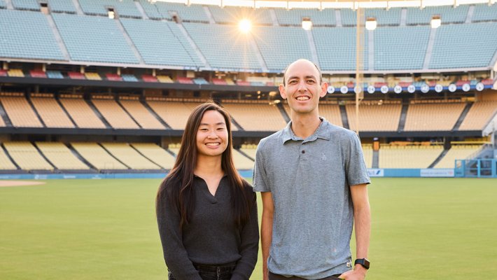 Grace Peng and Ryan Casey stand on the field at Dodger Stadium