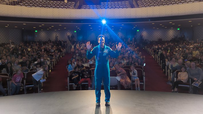 Jessica Watkins poses for a photo with the crowd in Beckman Auditorium