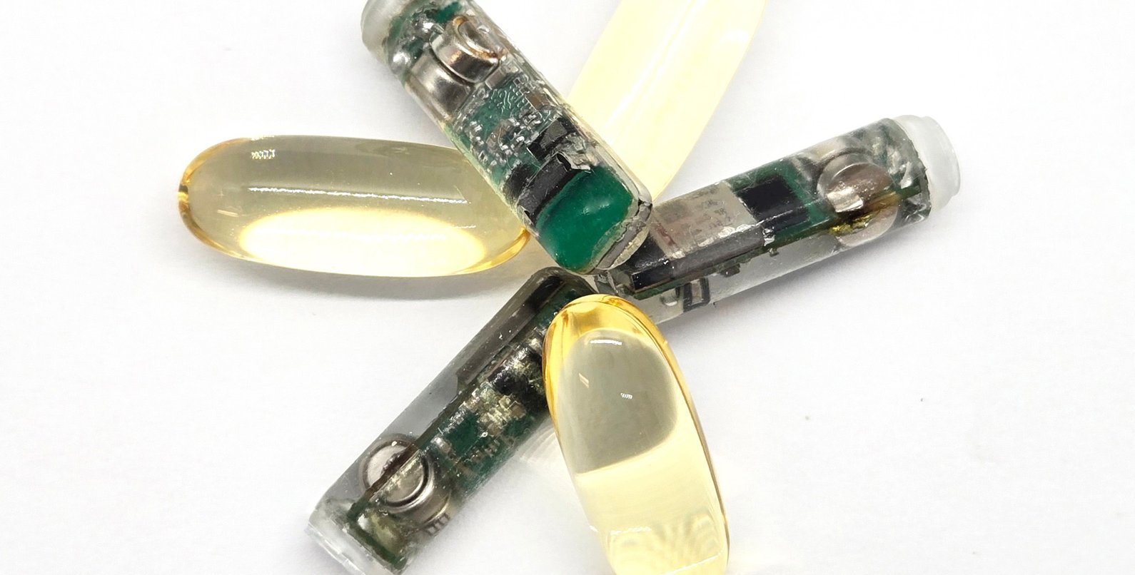 three smart capsules alternating in a flowerlike pattern with regular capsules, for size comparison purposes