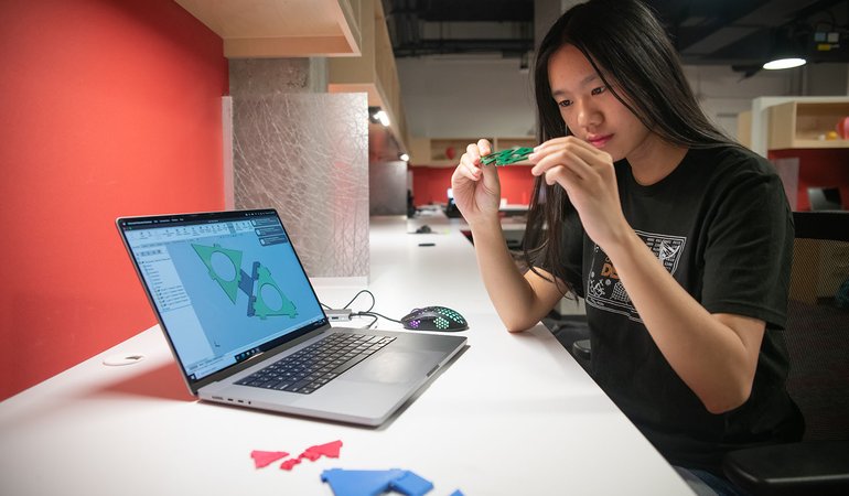 Woman works with plastic shapes by computer