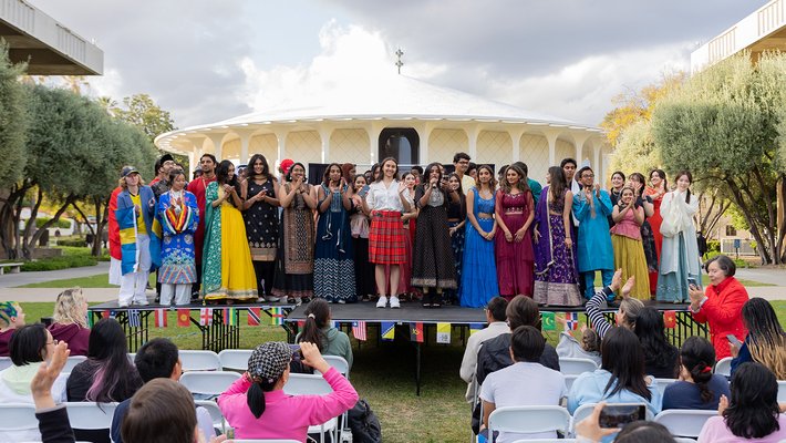 A group of students stands together on stage at World Fest