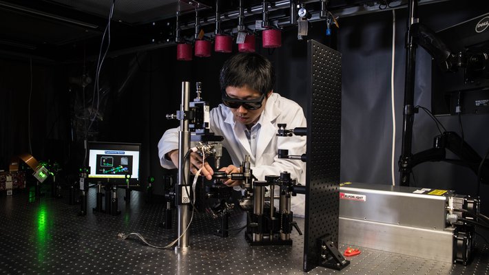 Jiamiao Yang, a postdoctoral scholar in the Caltech Optical Imaging Laboratory, adjusts a photoacoustic microscope.