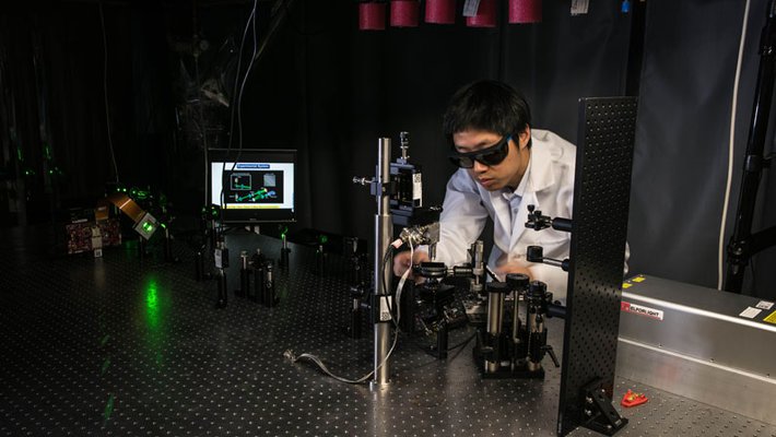 Jiamiao Yang, a postdoctoral scholar in the Caltech Optical Imaging Laboratory, adjusts a photoacoustic microscope.