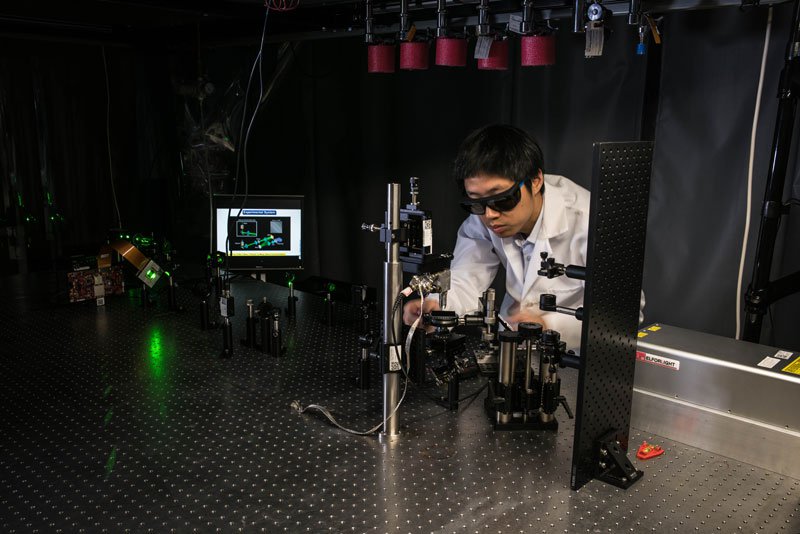 Jiamiao Yang, a postdoctoral scholar in the Caltech Optical Imaging Laboratory, adjusts a photoacoustic microscope.