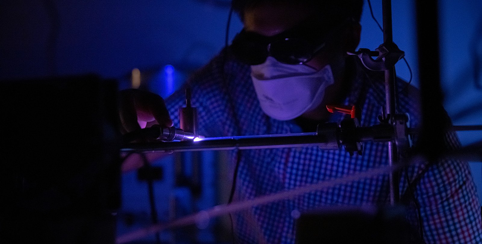 Glowing hot pink plasma can be seen in a dark laboratory room.