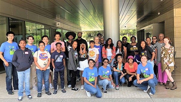 People gather, smiling, for a group photo