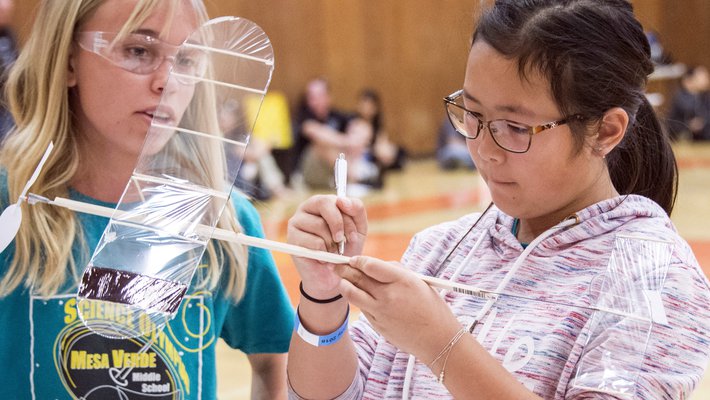 Emilia Ellegaard and Amy Wang, from Mesa Verde Middle School, prepare to launch their rubber-band-powered airplane; their goal was to have the airplane stay aloft as long as possible.