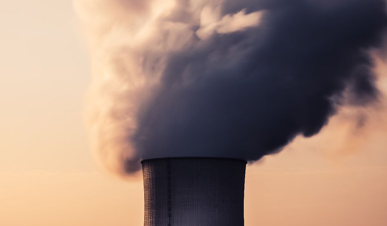 Steam billows out of a cooling tower of a power plant