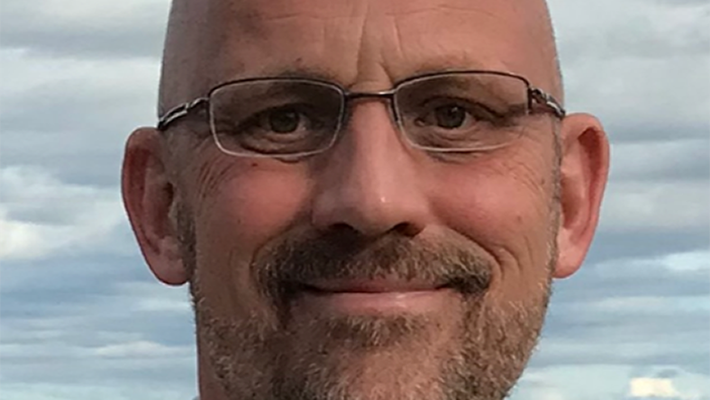A portrait of Tim Colonius in front of a partly cloudy sky.