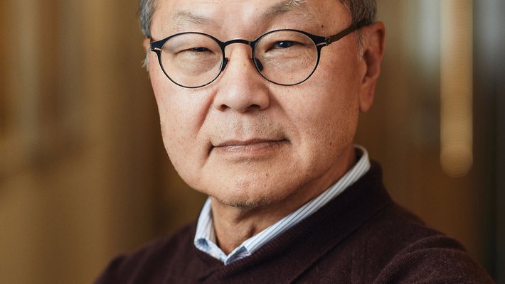 Portrait of David Ho wearing glasses and a sweater