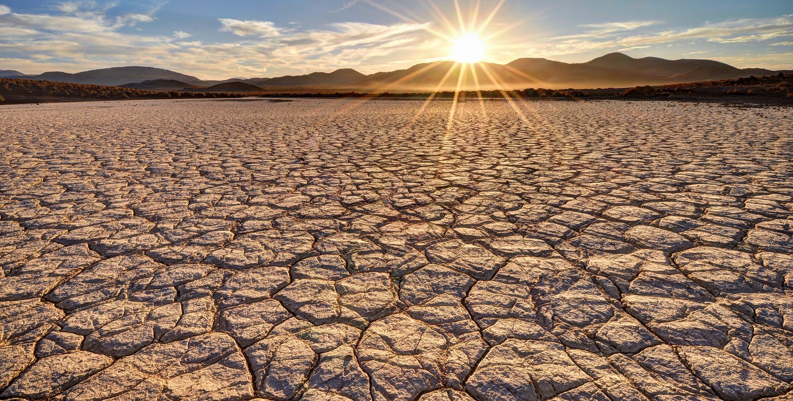 A desert with a sunrise above