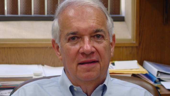 A pink flower blooms, surrounded by lily pads.