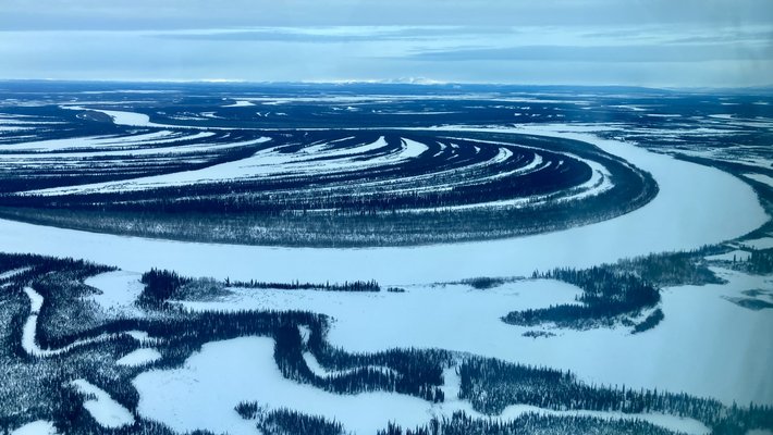 A dark blue river along white ground