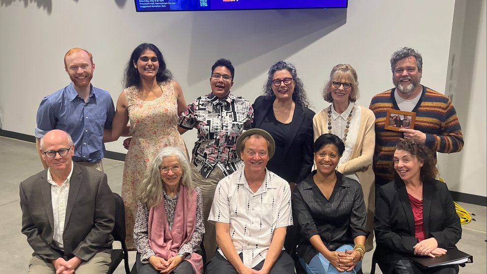 A group of people pose in front of a screen that says "Dementia Doula"