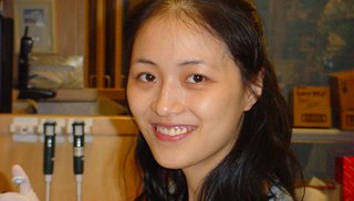 woman faces camera while working in a chemistry lab